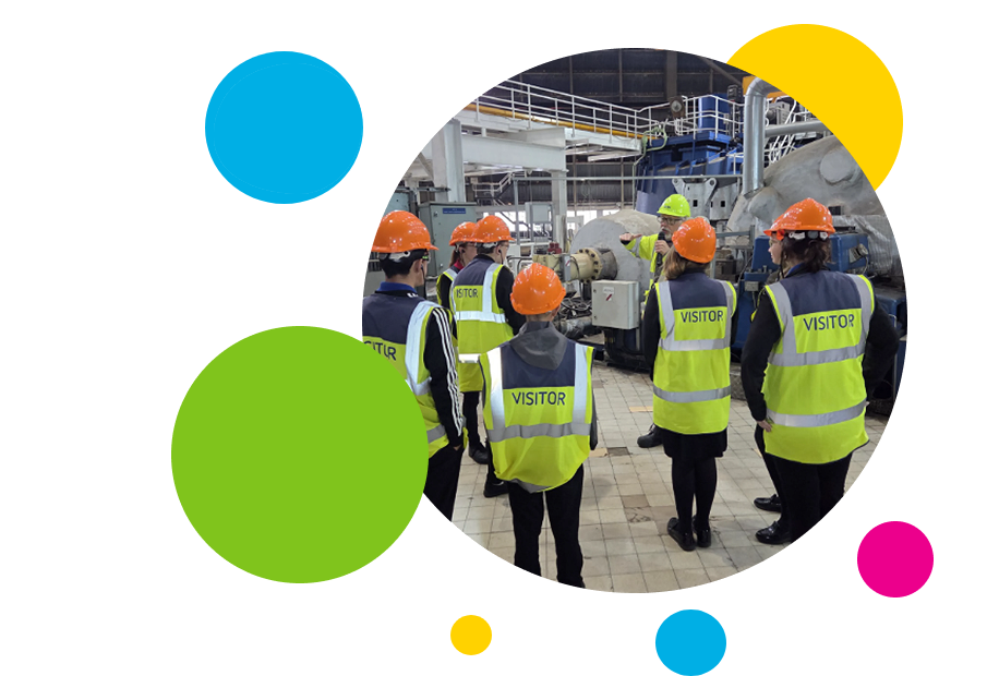 People in hard hats touring an industrial facility